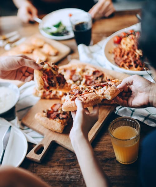 Friends sharing a pizza near Lakeside Terraces in Sterling Heights, Michigan