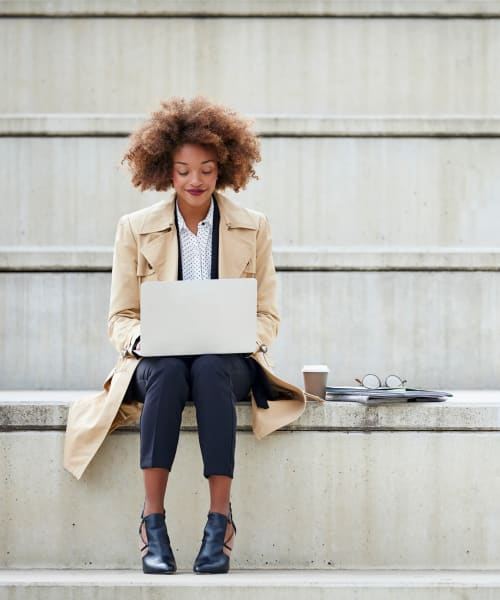 Stylish professional working on her laptop outside of the office at Beztak Properties